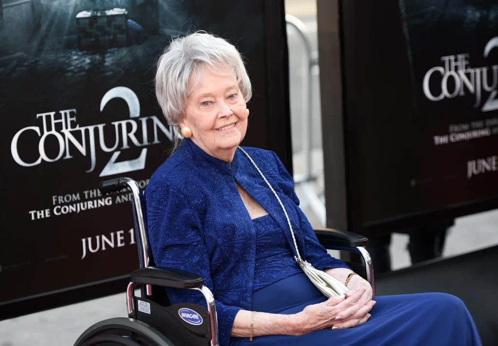 Lorraine Warren in front of conjuring poster