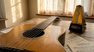guitar on floor with papers